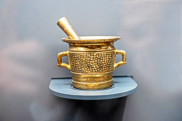 bowl with a mortar for grinding chocolate beans on a gray background