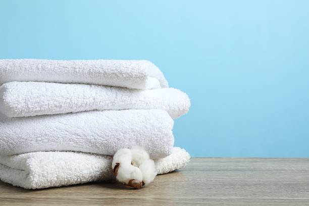 istock Stack of bath towels with cotton flower on the table 2254283341