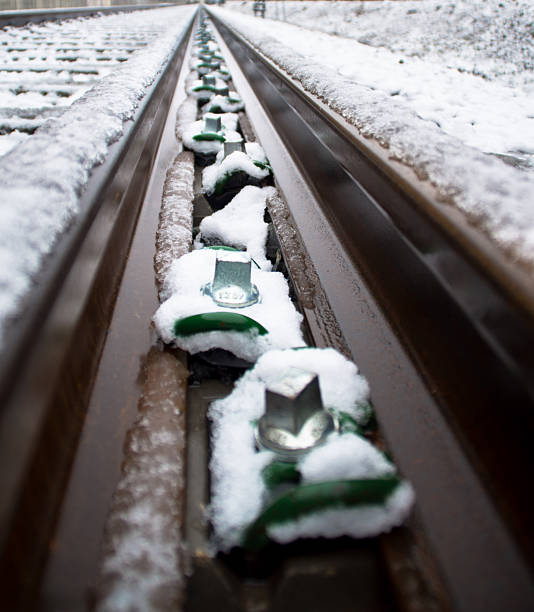 istock Railroad tracks converging in snow covered winter landscape 2254283917