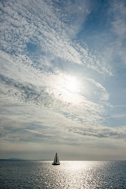 A ship sailing away across calm blue sea under a clear sky. The minimalist maritime scene symbolizes travel, freedom, journeys, departures, and open horizons, suitable for travel and lifestyle concepts.