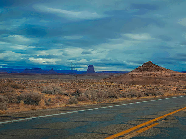 istock Dramatic desert landscape with a winding road under a stormy sky 2254288073