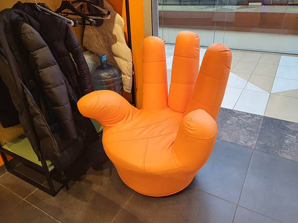 A fun modern orange leather armchair shaped like a human hand