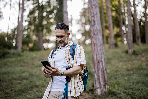 istock Hiker Checking Map on Smartphone While Trekking in Nature 2254290584