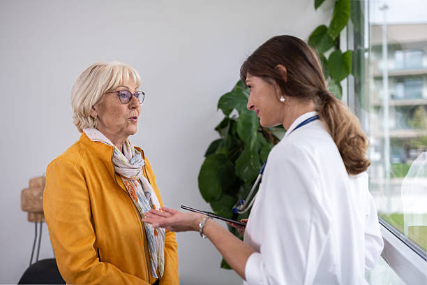 istock Female Doctors Talking To Elderly Patient In Hospital Reception 2254294411