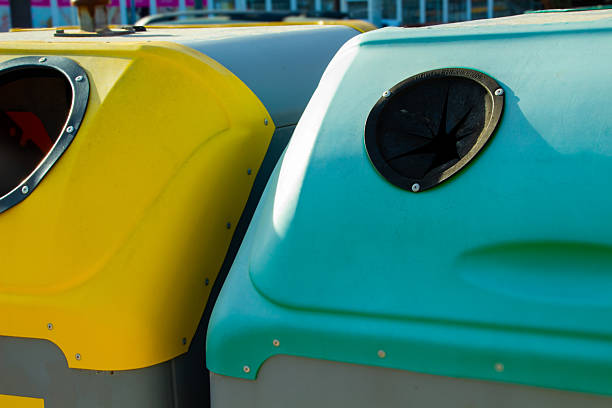 Close-up of colorful recycling bins with round openings.