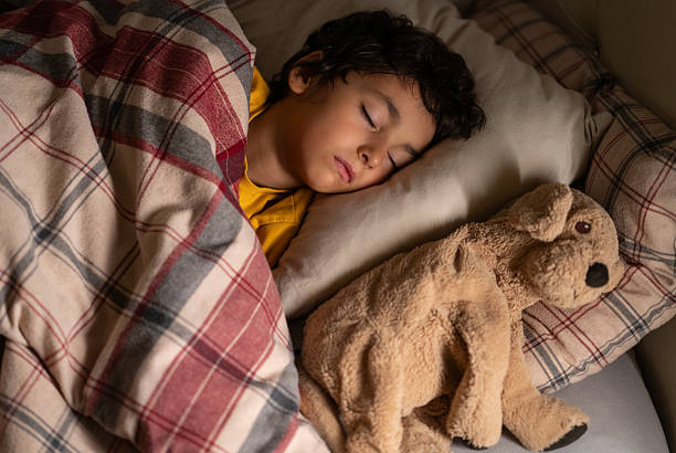 istock Peaceful little boy sleeping in bed with a stuffed dog toy 2254299081