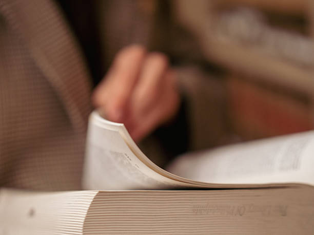 istock Person flipping through pages in a cozy indoor setting 2254300822