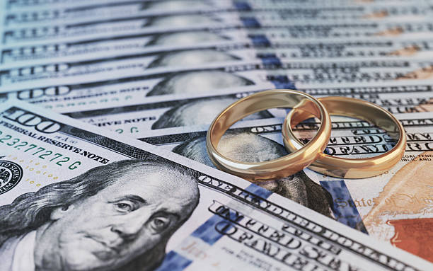 istock Wedding Rings on US Dollar Bills Representing Financial Commitment in Marriage 2254302310