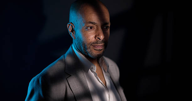 African American man looking away in studio with striking blue light and shadows