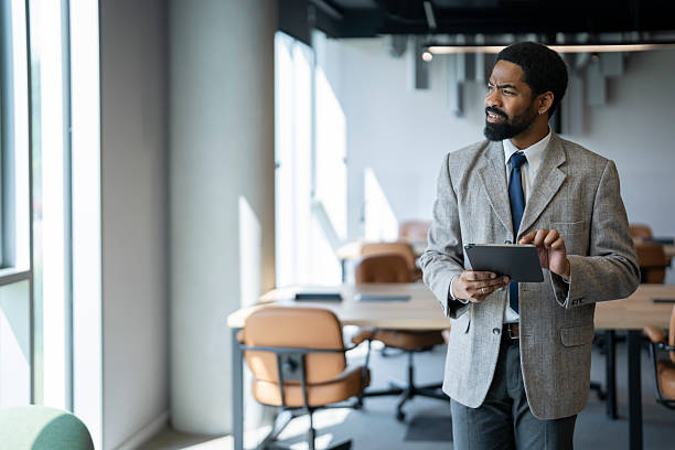 istock Pensive businessman using digital tablet in modern office 2254312274