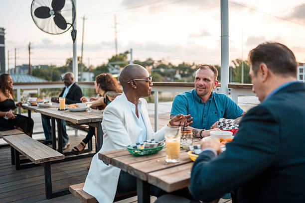 istock Diverse Group Engages in Lively Dinner Conversation on Rooftop Patio 2254312364