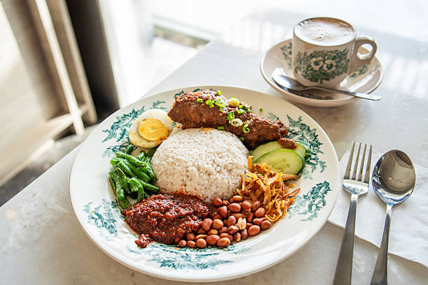nasi lemak - traditional Malay cuisine with sambal, chicken and rice cooked with coconut milk on a dining table