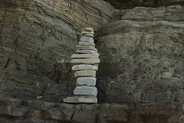 Tidy stack of smooth pebbles at the beach. Framed from above. Variegated texture.