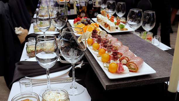 istock Wine glasses surrounding gourmet appetizers resting on dramatic black white checkered tablecloth, highlighting elegant catered dining experience 2254320200