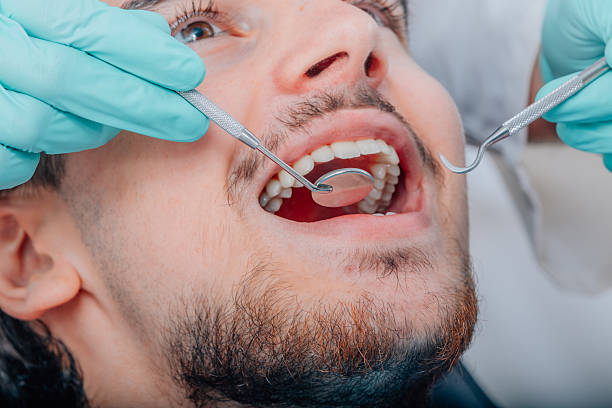 istock patient mouth with dentist tools 2254321719