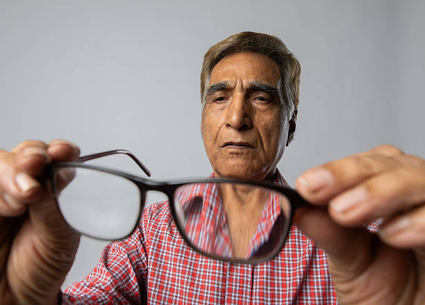 istock Old man checking his eyeglasses on white background 2254321857