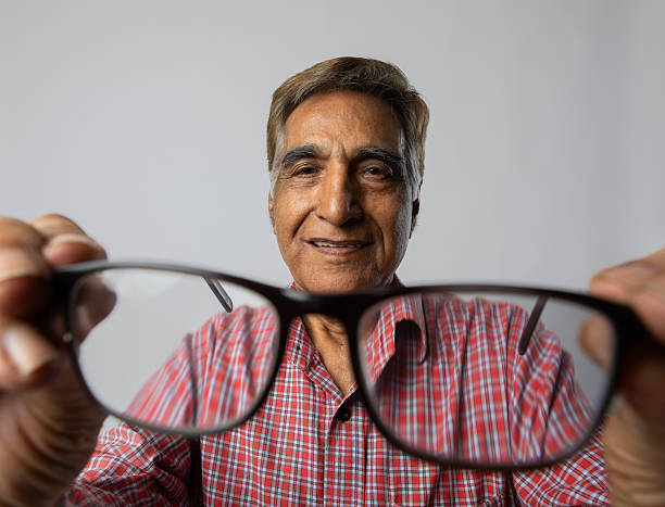 istock Old man checking his eyeglasses on white background 2254321915