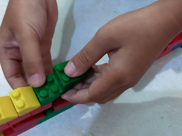 istock Child Hands Playing with Colorful Building Blocks 2254322947