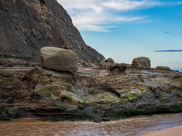 istock Coastal rock formations and beach with cloudy sky 2254324752