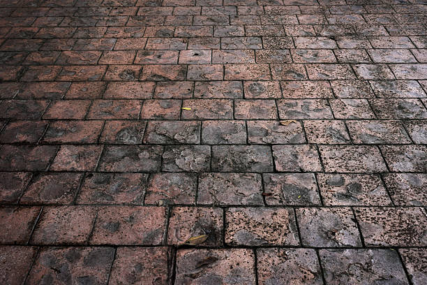 Point of view of feet on a cobblestone street. Walking away.