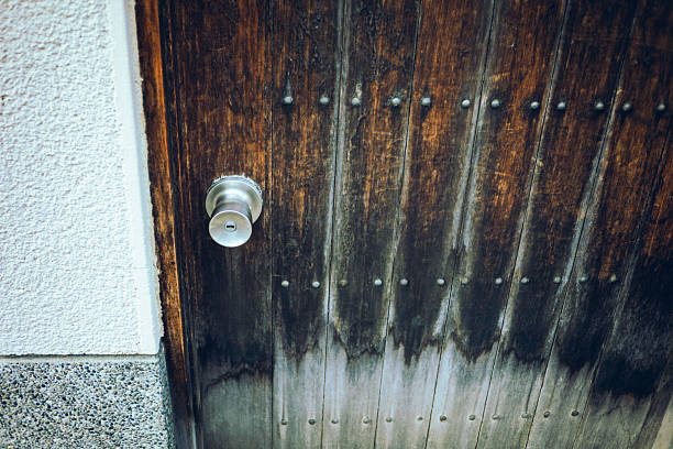 Front view old and weathered wooden door and empty wall in the room