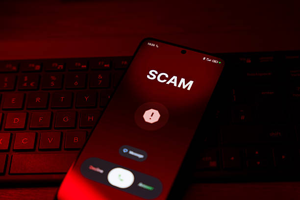 istock Scam warning on smartphone screen with call options over keyboard, red light 2254328885