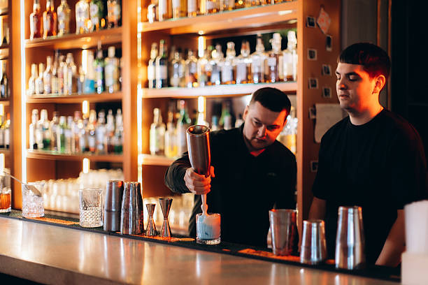 istock Bartenders Preparing Cocktails in a Stylish Bar with Beverage Options 2254330129