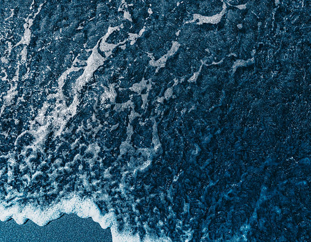 istock dark wave on  sand beach, closeup, topview 2254330503