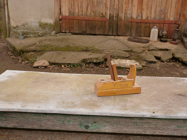 Old wooden hand plane on work surface, traditional carpenter tool.