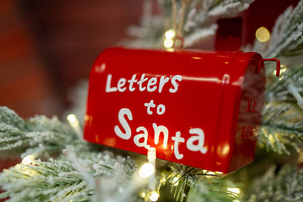 istock Red Christmas mailbox for Santa hanging on snowy pine branch 2254339623