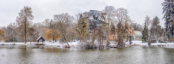 Saran, France. Winter snow covering trees and land around a reflective lake, showing a serene natural landscape
