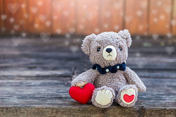 istock Teddy bear and red heart with space on wood background 2254339982
