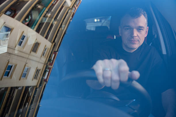 istock Man behind the wheel seen through windshield 2254340594