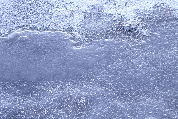 Close-up of blue ice texture on a smooth frozen lake in winter. Cold, crystal-clear natural background conveying freshness, calm, and winter atmosphere.