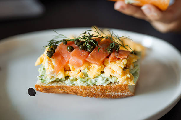 istock Woman holding salmon sandwich with whole wheat bread. 2254344986