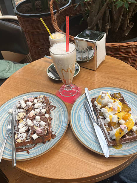istock Cups of coffee with waffles in interior cafe, 2254349045