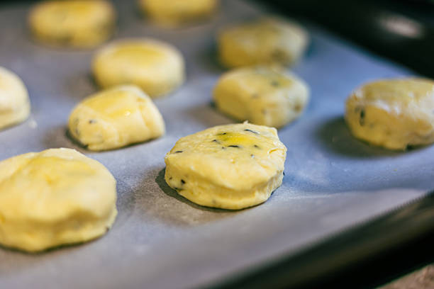 Close-up view of a freshly baked tray of hot, savoury cheese scones straight out of the oven.