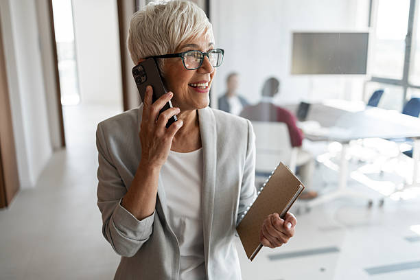 istock Business Professional Woman Smiling While Talking On Phone In Modern Office Space 2254351030