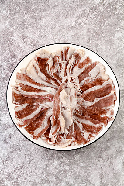 resh raw beef sliced with rich fat marbling served on a white plate