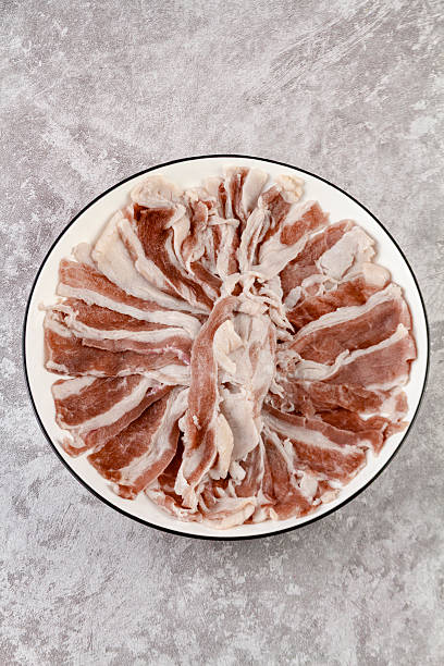 resh raw beef sliced with rich fat marbling served on a white plate