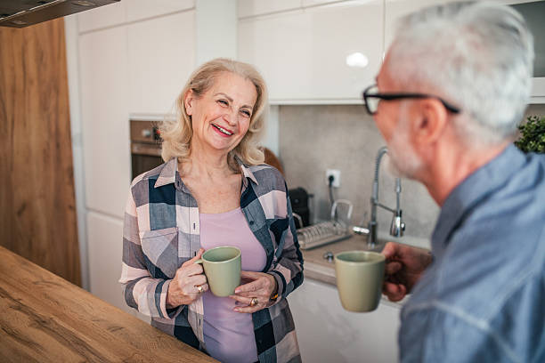 istock Senior couple standing at the kitchen counter, drinking coffee and chatting together 2254354989