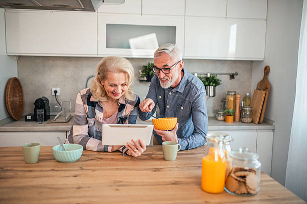 istock Mature couple having video call on digital tablet while eating breakfast cereal in kitchen 2254356153
