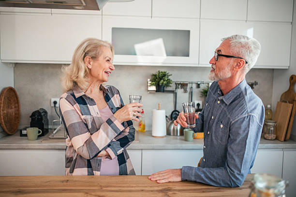 istock Happy mature couple drinking water and chatting in kitchen 2254356651