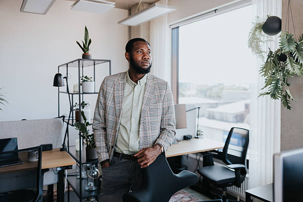 istock Confident professional stands in a modern, plant-filled office 2254359907