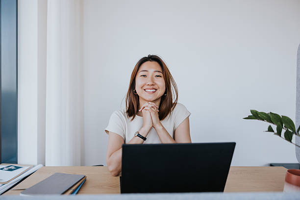 istock Smiling woman in a modern office at desk 2254359945