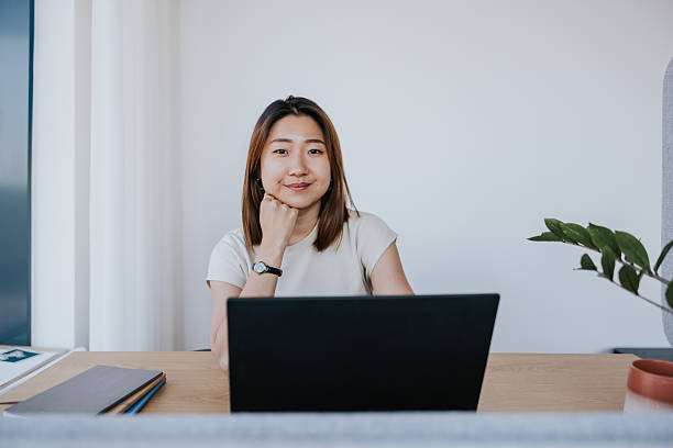 istock Thoughtful Asian woman at a modern office desk 2254359946