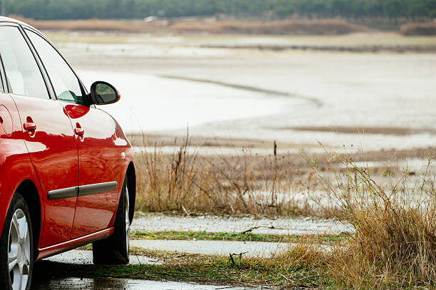istock Red Car Parked Near Lake 2254362654