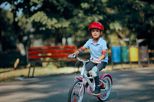 Kid learning how to go on a bike ride wearing a helmet and pads