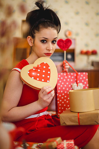 portrait of a little girl in a red beret and clothes on a background of colorful hearts, a smiling child, the concept of valentine's day and love
