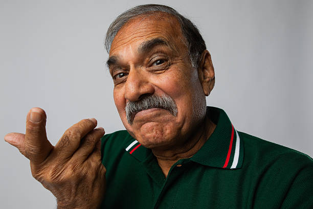 Portrait of senior man gesture while standing against white background